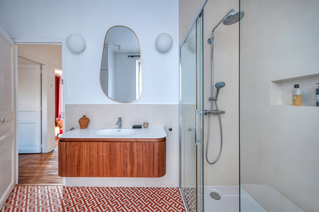 Salle de bains de maison meulière avec carreaux géométriques contemporains posés à 45 degrés et meuble vasque suspendu en bois