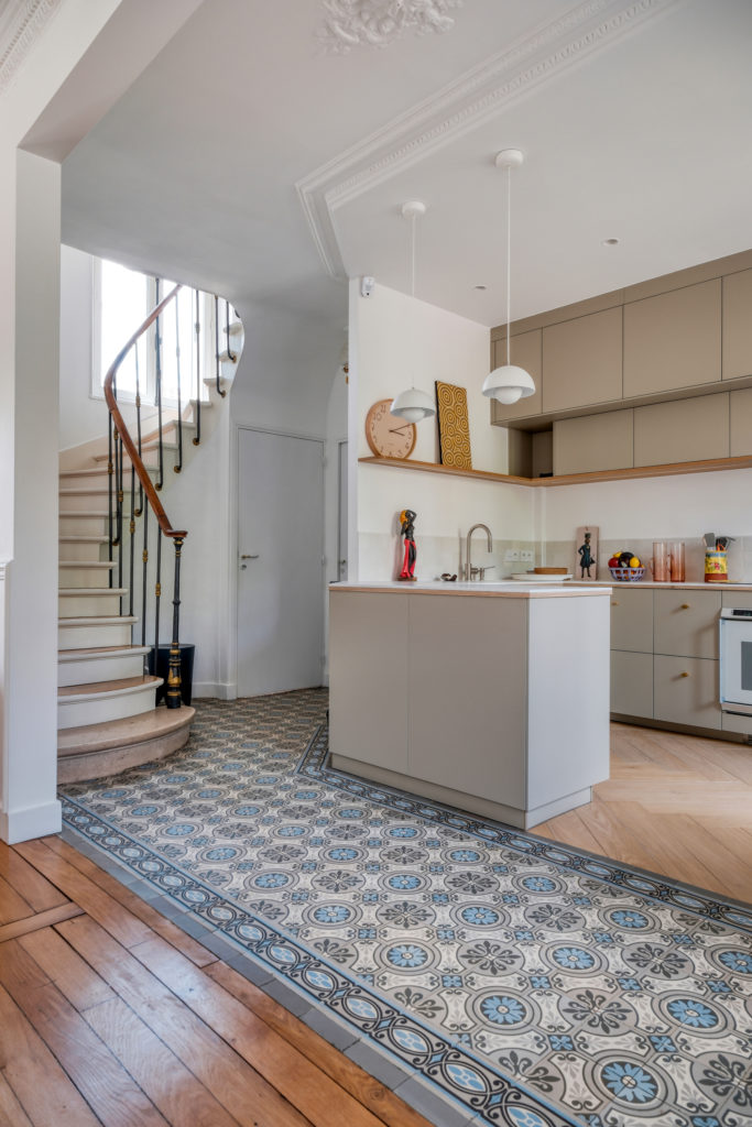 Rénovation d'une maison meulière à Versailles par Agence Avous : vue de l'entrée avec carreaux de ciment d'origine rénovés et transition vers le parquet
