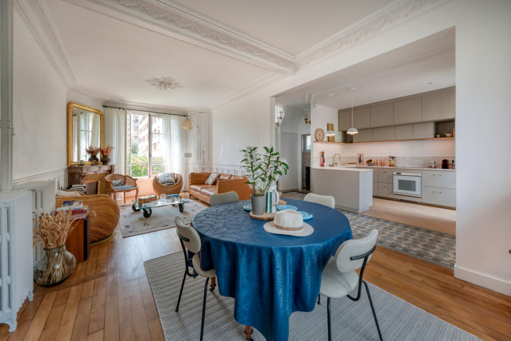 Salon et salle à manger d'une maison ancienne autour d'une cheminée en marbre d'origine et ouvertures sur l'extérieur