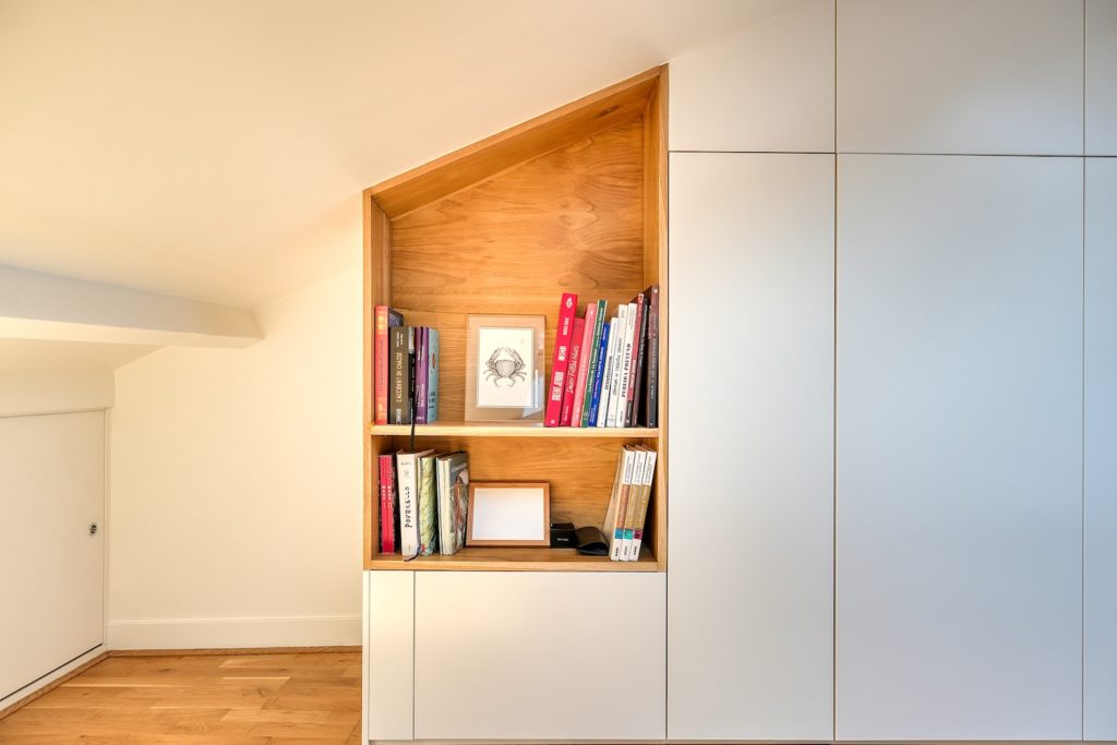 Chambre sous combles avec grand dressing sur mesure blanc et niche de tête de lit en bois