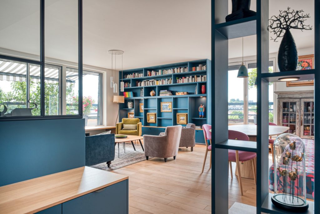 Entrée de l'appartement en boîte bleue avec meuble vasque et verrière sur mesure