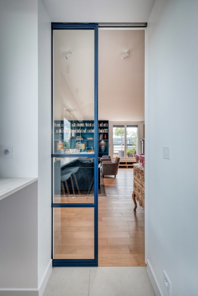 Porte verrière coulissante type atelier séparant la cuisine tout en laissant passer la lumière