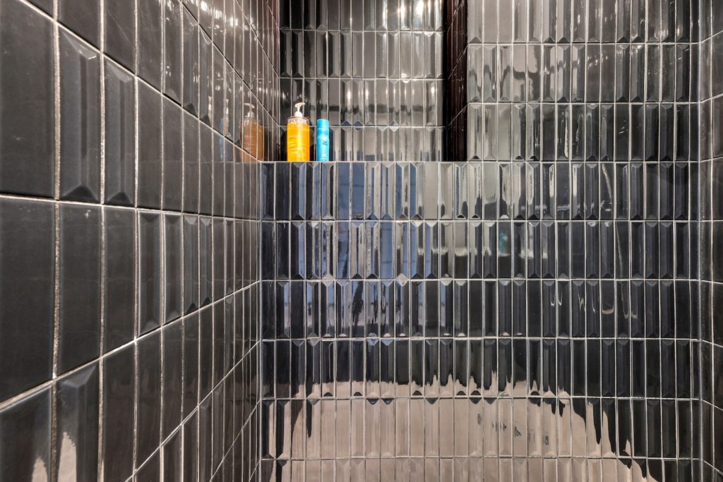 Salle de bain avec faïences verticales Flauti de chez Vogue et robinetterie Treemme en inox brossé